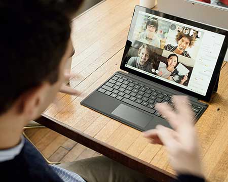 Ein Mann vor einem Laptop gestikuliert in einem Videocall