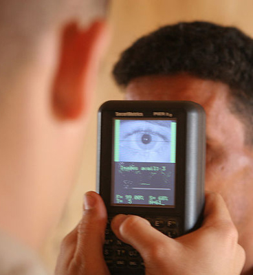 Eine Person scannt die Iris einer zweiten Person mit einem speziellen Gerät.